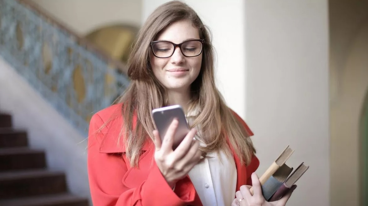 Estudante segurando celular na mão